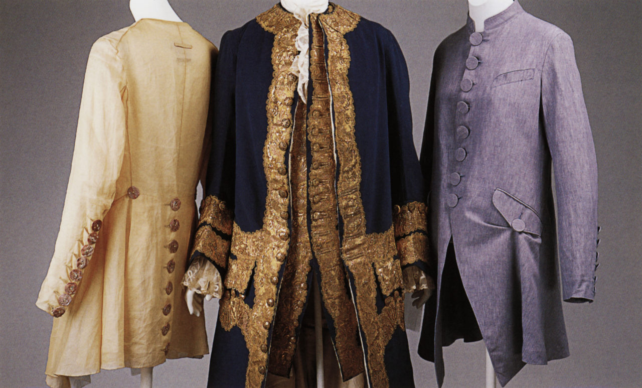 Two women's coats flanking an 18th-century man's suit