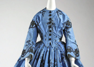 1863 – Blue silk dress with black floral embroidery