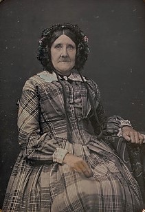 Seated Elderly Woman Wearing Plaid dress and Bonnet