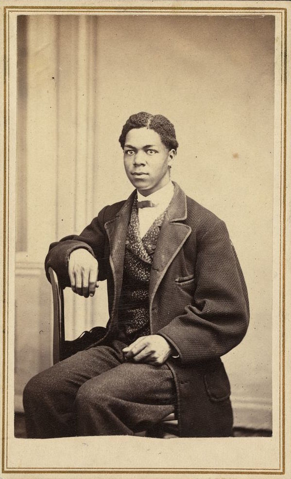 Three-quarter-length portrait of an unidentified African American man, wearing suit, seated