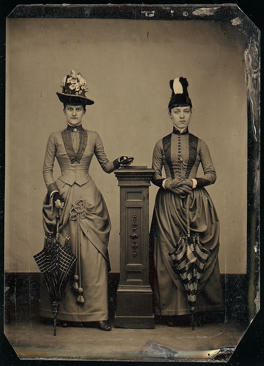 [Studio Portrait of Two Women Holding Folded Parasols]